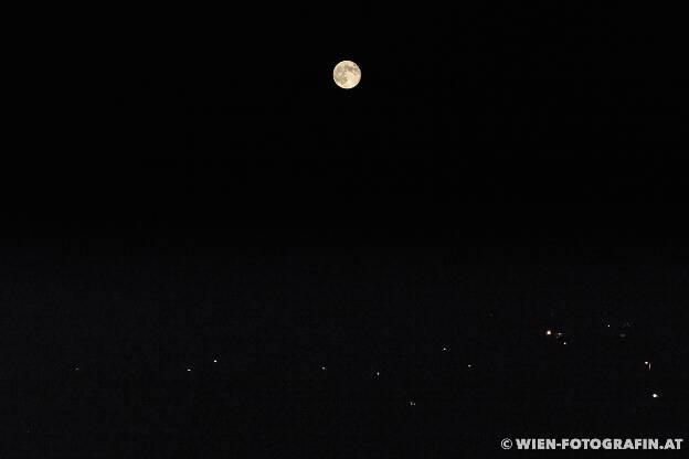 Der Mond steht über meinem kleinen Dorf. Man sieht nur ein paar Lichter.